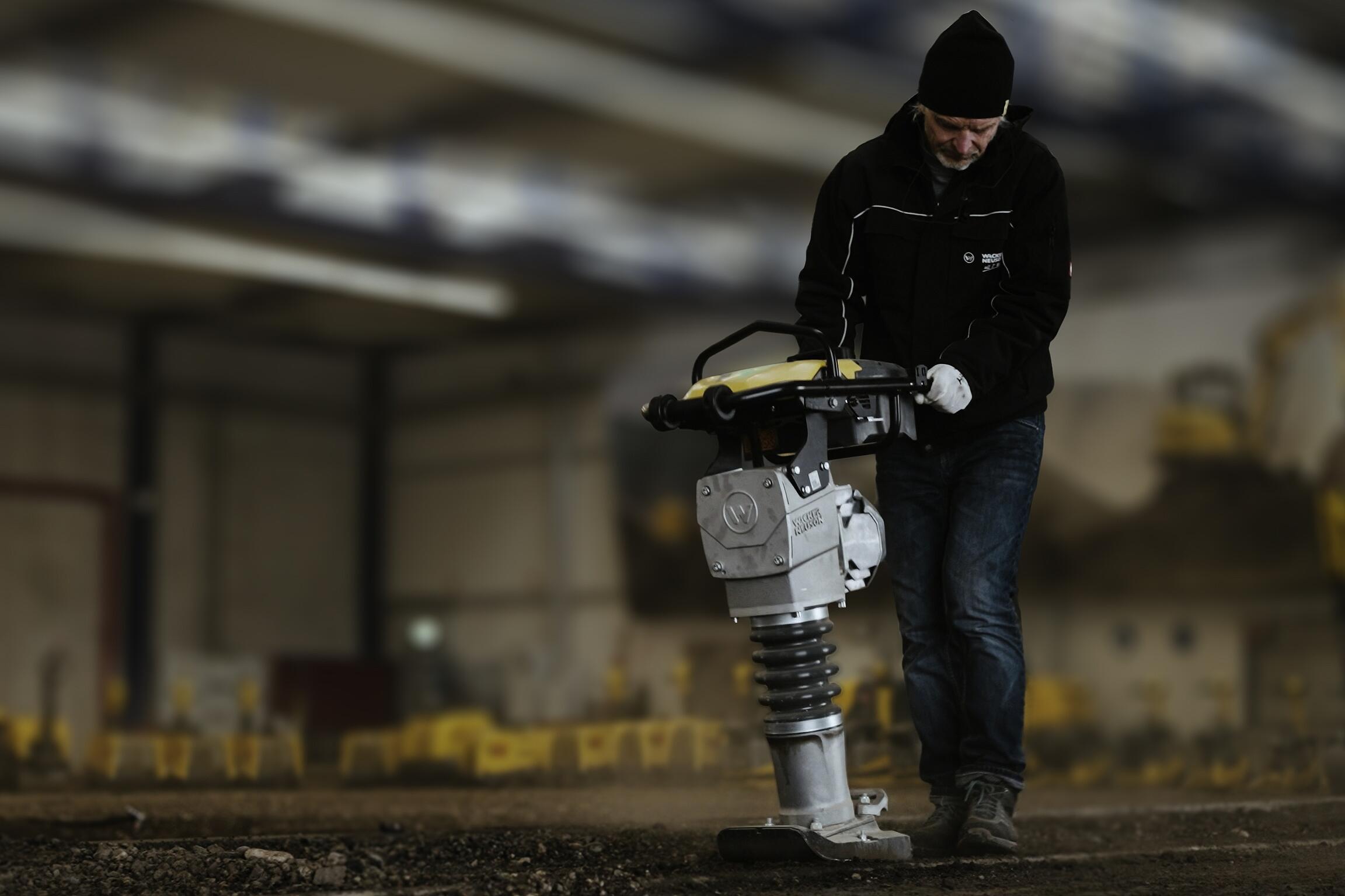 Worker operating rammer for soil compaction in indoor construction training environment