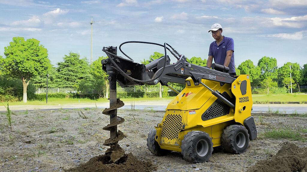 Мини-погрузчик на колесах со шнеком в действии