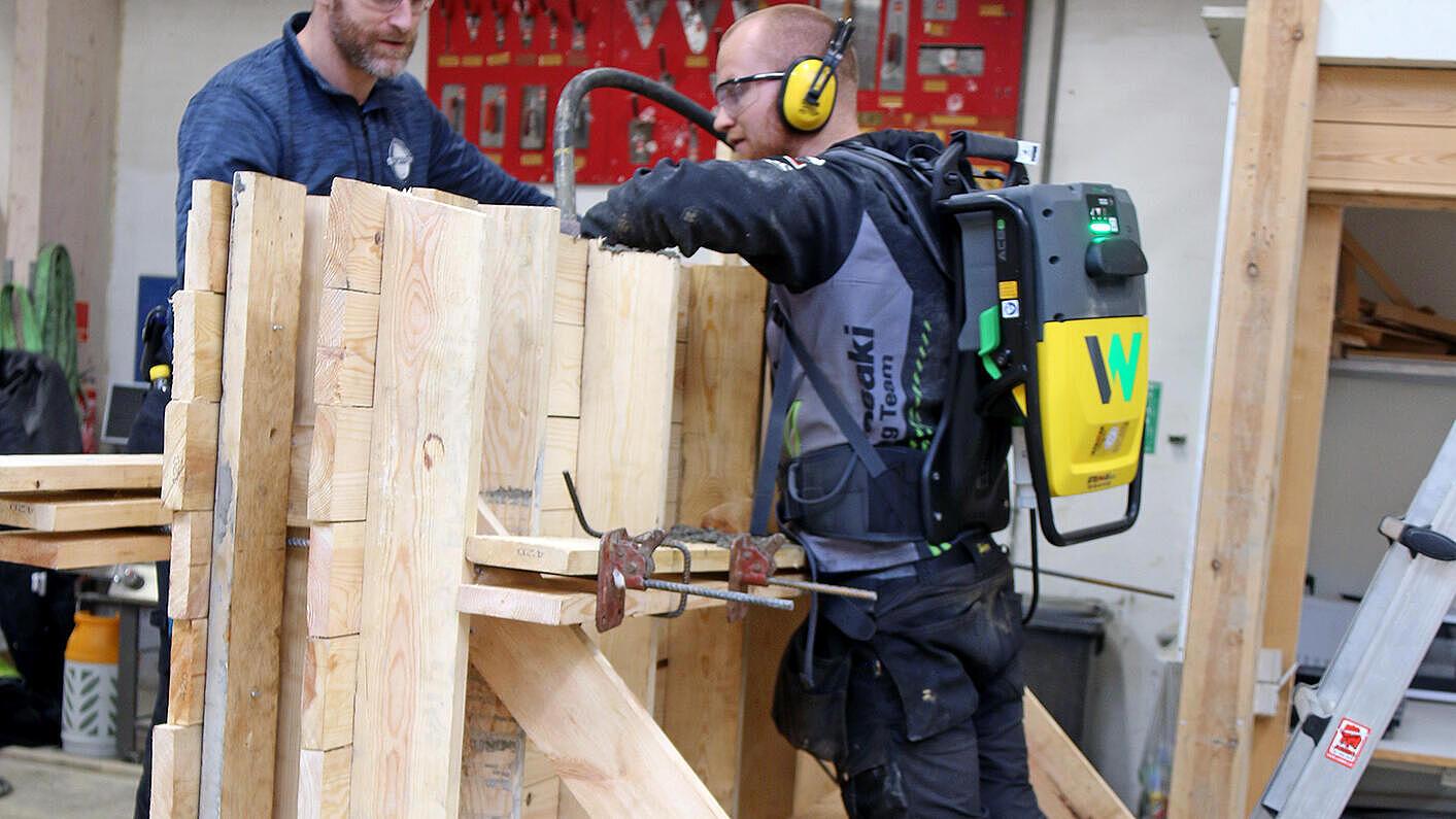 Teacher Benny Christensen (left) follows the process while one of the structural engineering students compacts concrete. The Wacker Neuson cordless, battery-powered internal vibrator is the first high-frequency internal vibrator system that can be worn as a backpack.