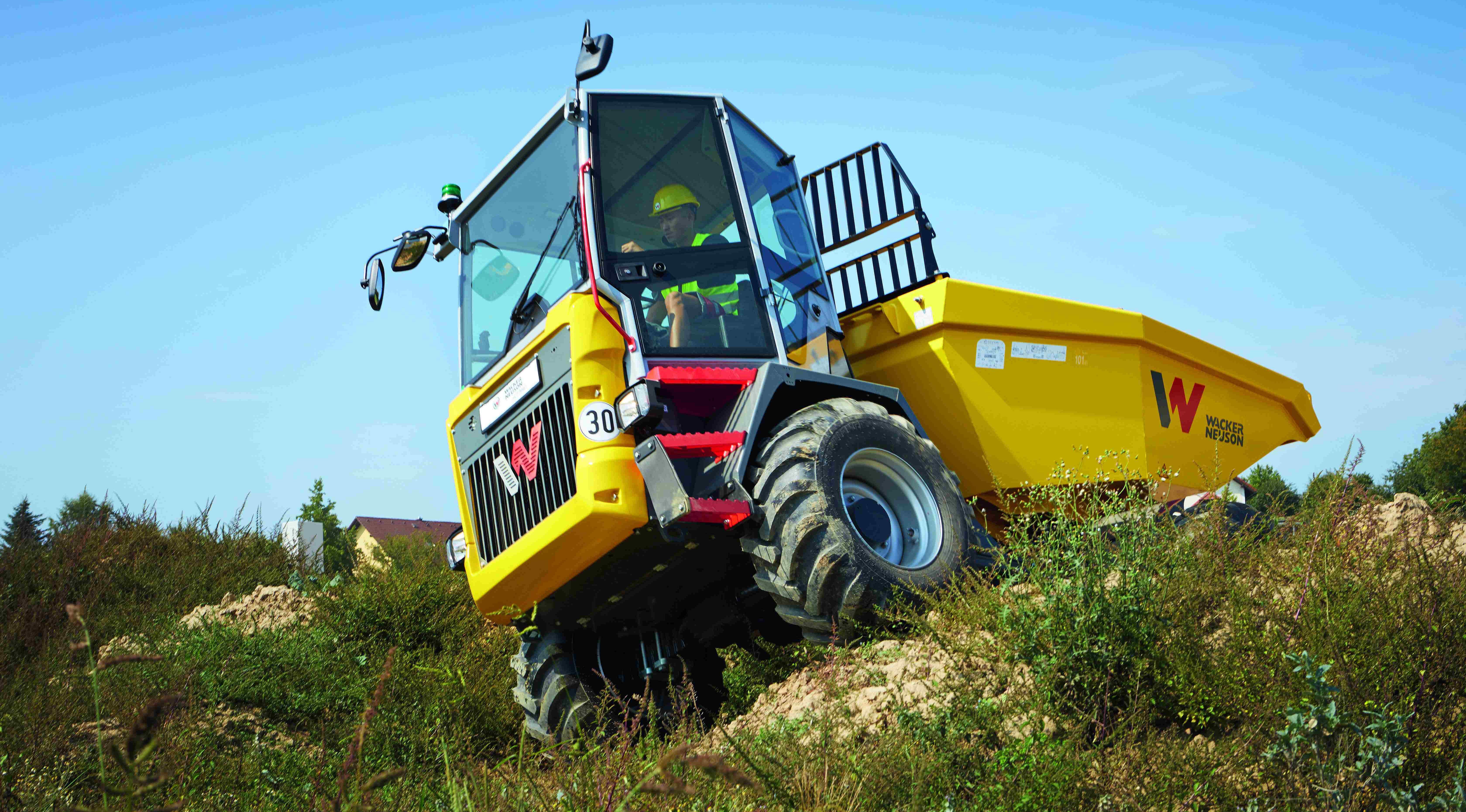 Wacker Neuson dumper driving on uneven terrain with operator in cab during construction work