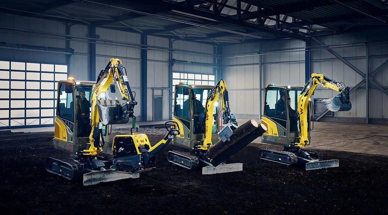 мини-экскаваторы, выстроенные в ряд в промышленном павильоне