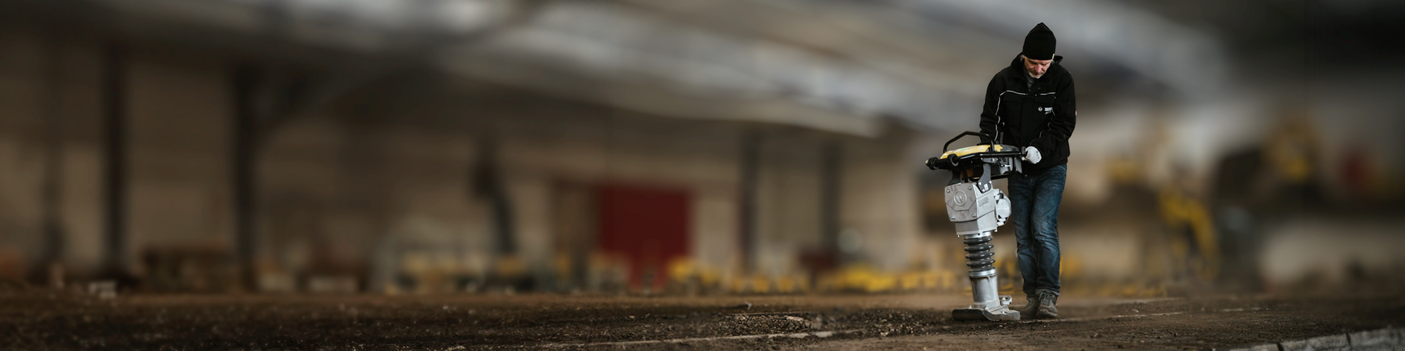 Man with electric rammer in a hall