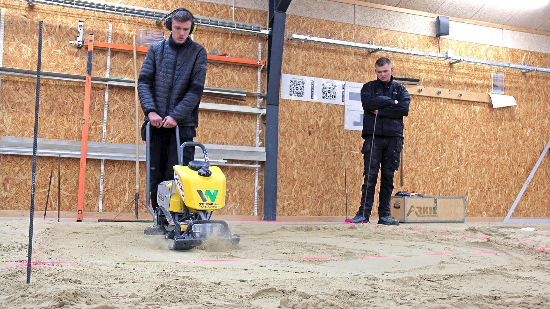 One of the construction students operates the battery-powered Wacker Neuson APS1340e vibratory plate.