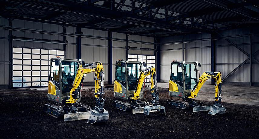 three yellow mini excavator in industry hall