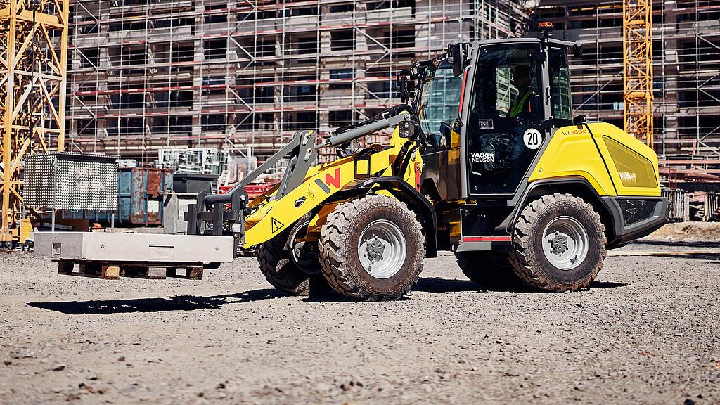 Wacker Neuson WL750p wheel loader unloading soil material and handling bulk material on a construction site.